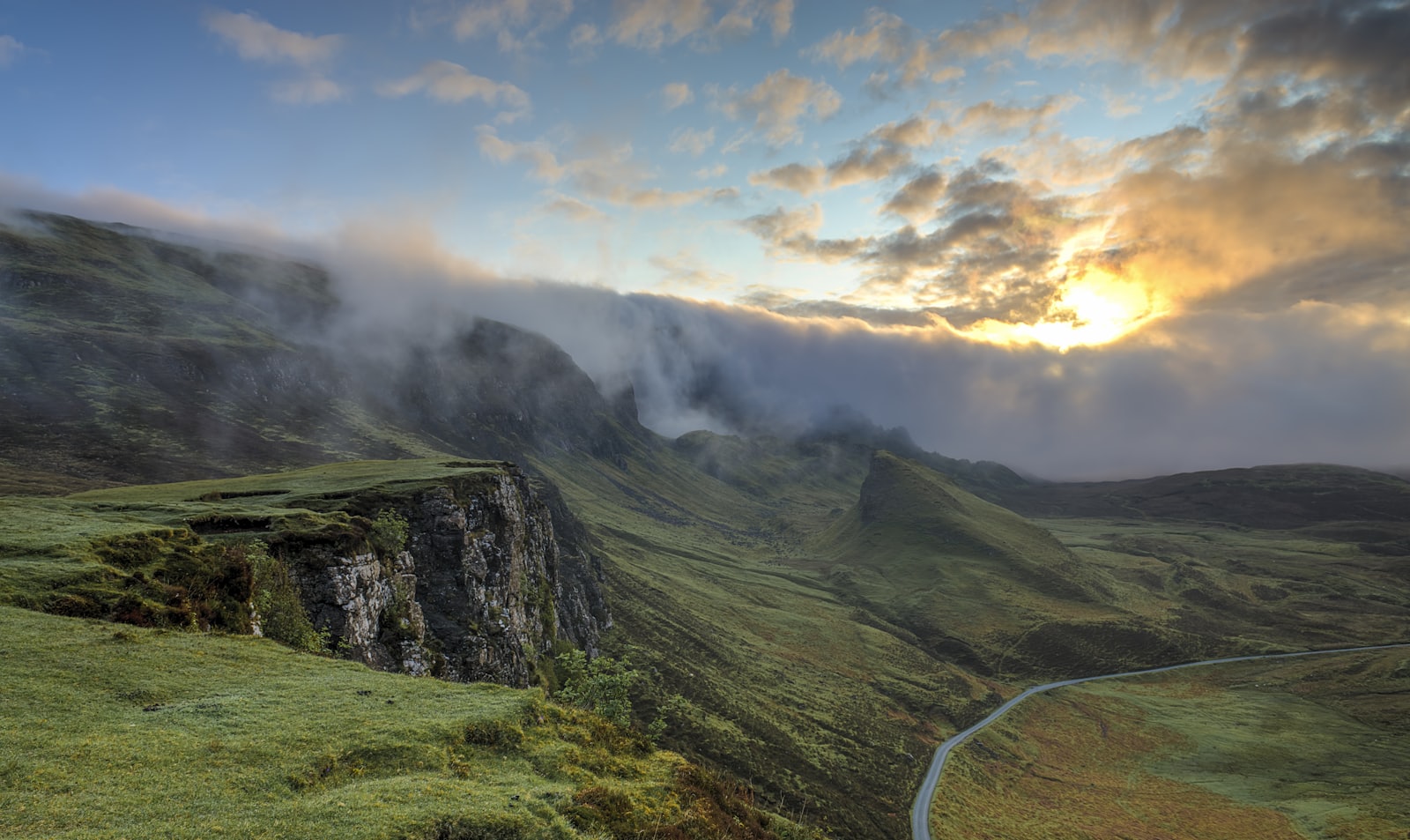 A road curving through open country at first light.